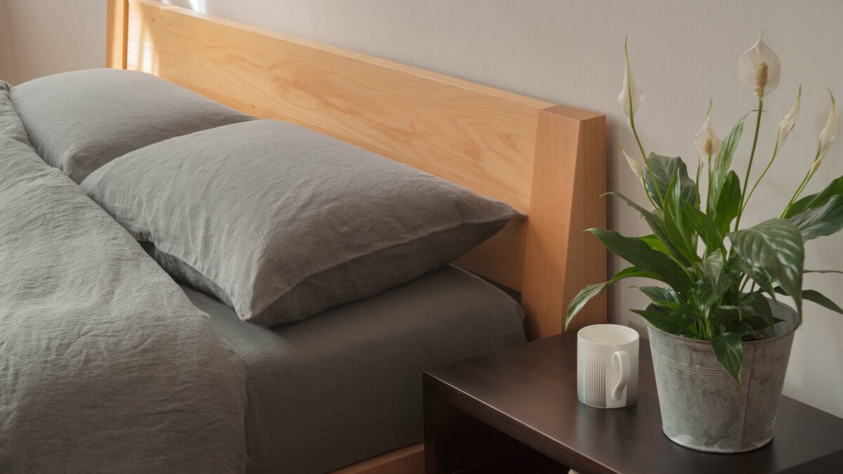 Java is a contemporary low solid wooden bed with a slanted headboard