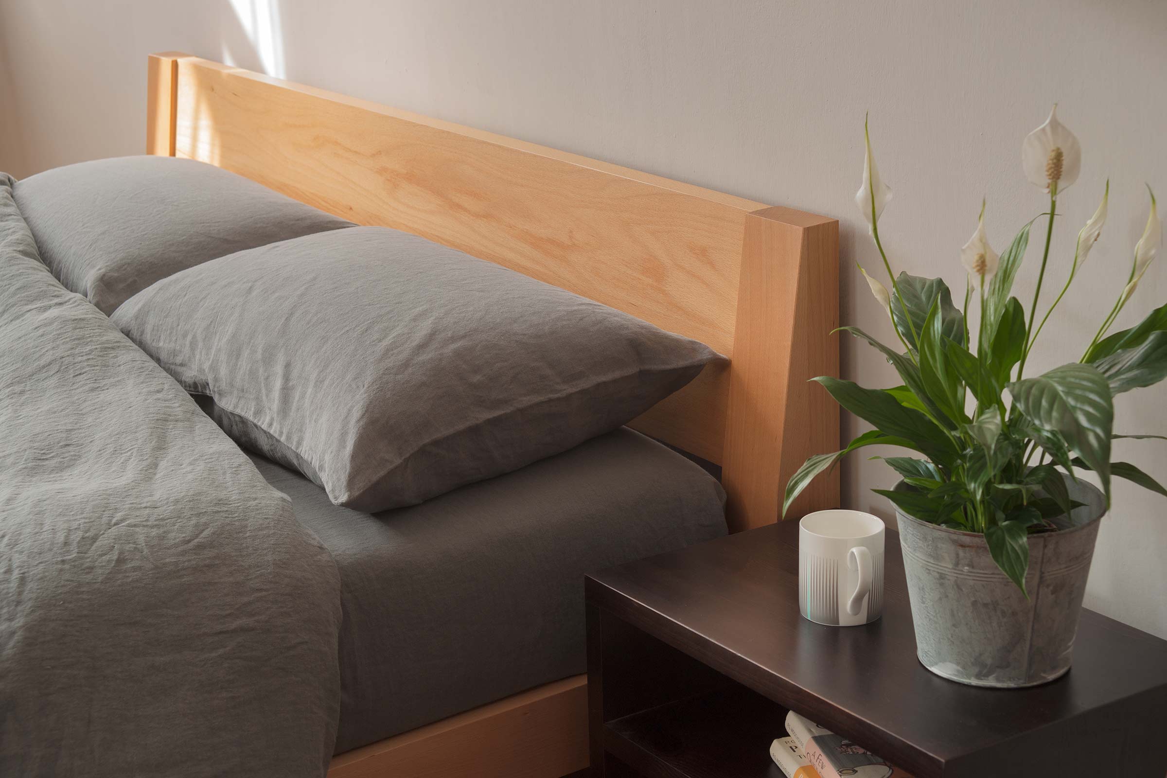 Java is a contemporary low solid wooden bed with a slanted headboard