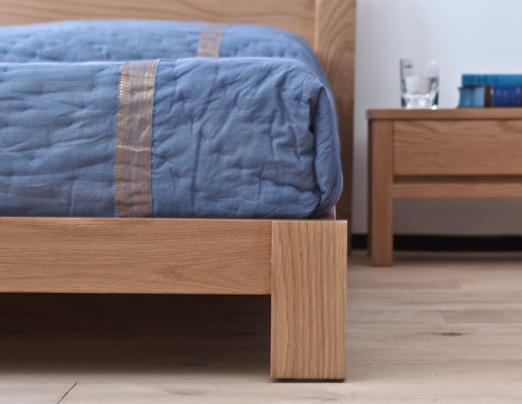 Close up of the leg of the Java low wooden bed in solid oak