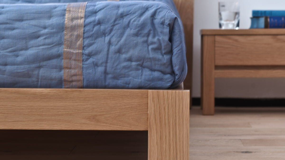 Close up of the leg of the Java low wooden bed in solid oak