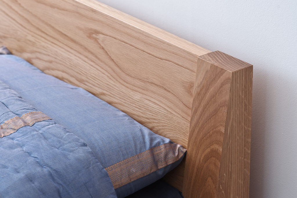 A closer look at the headboard of the Java low wooden bed in solid oak