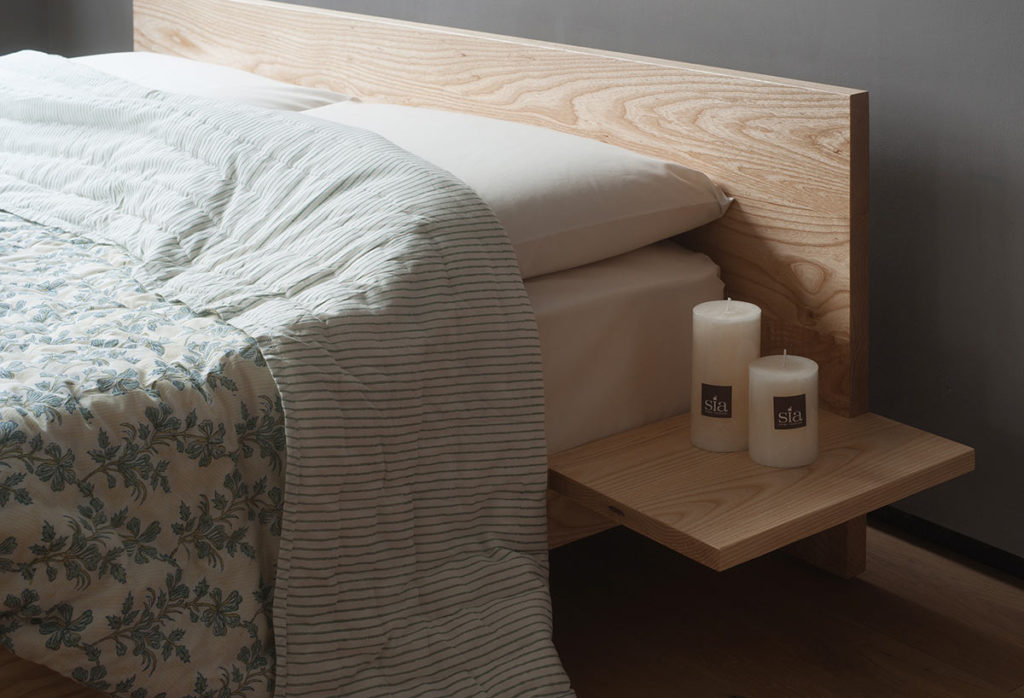 A closer view of the optional attached side tables on our hand made low Kulu wooden platform bed