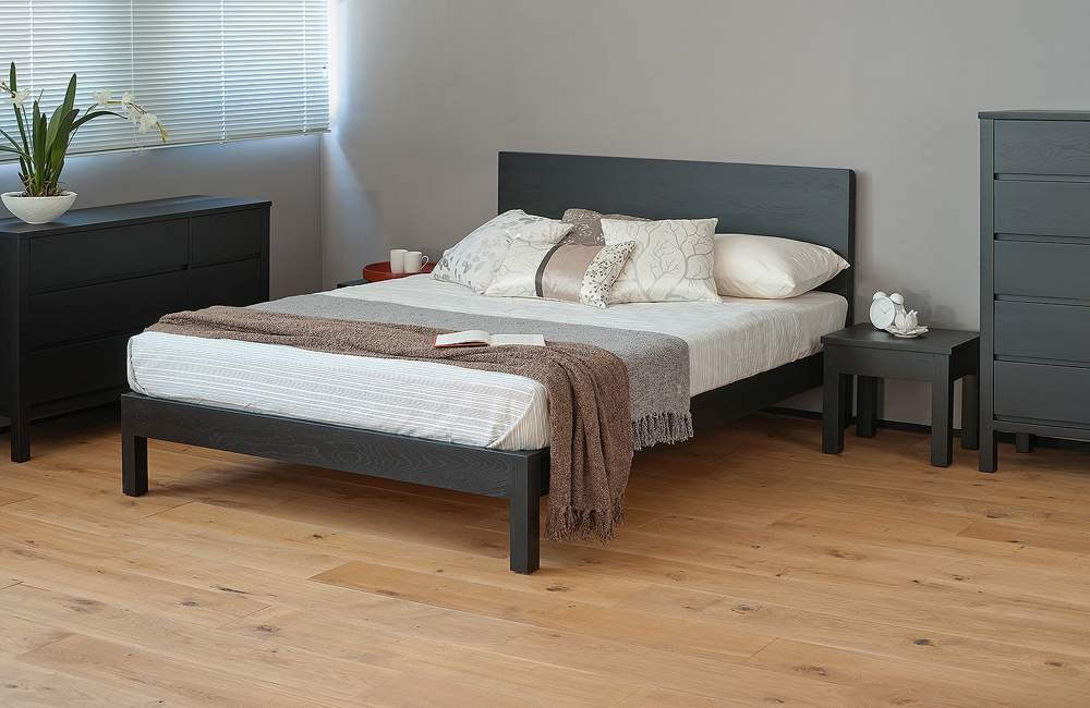 Monochrome bedroom style featuring a Black-painted Oak Malabar wooden bed and matching bedroom storage furniture