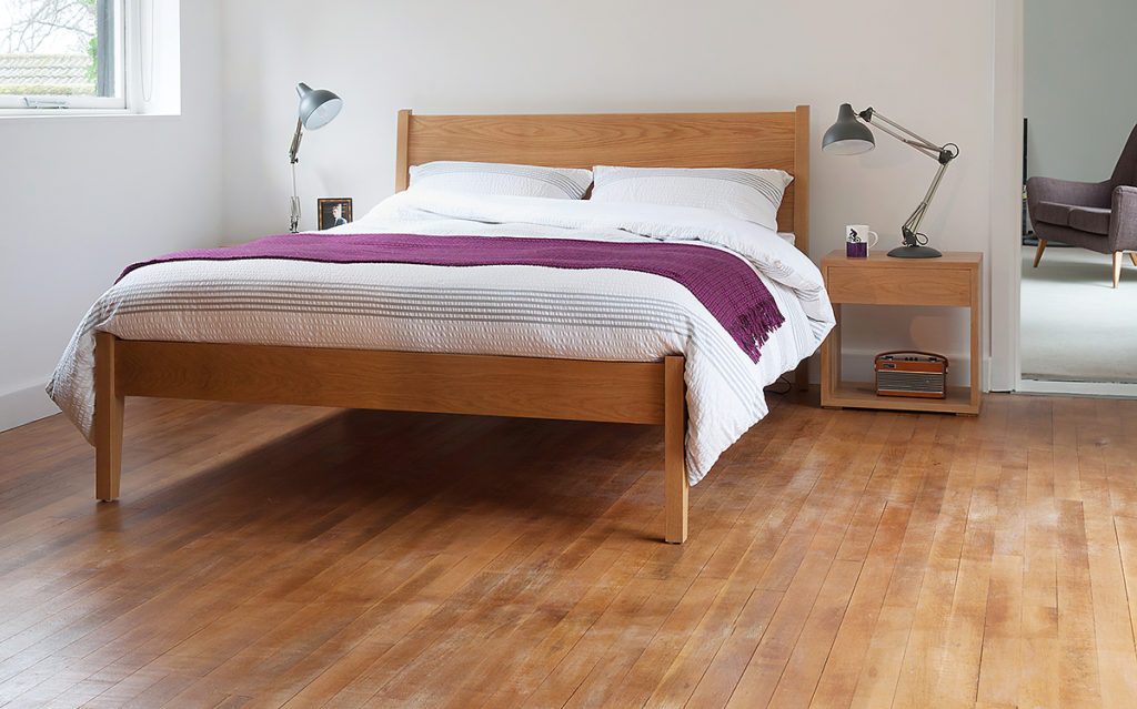 The Zanskar bed a modern classic wooden bed shown in oak with Oak Cube bedside tables.