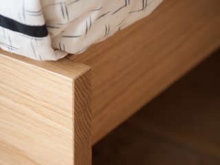 close up of the foot end of the Koo oak wooden bed