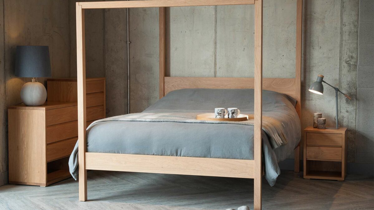 The Oasis a hand made wooden 4-poster bed here in solid oak, shown with black lotus Cube chests of drawers.