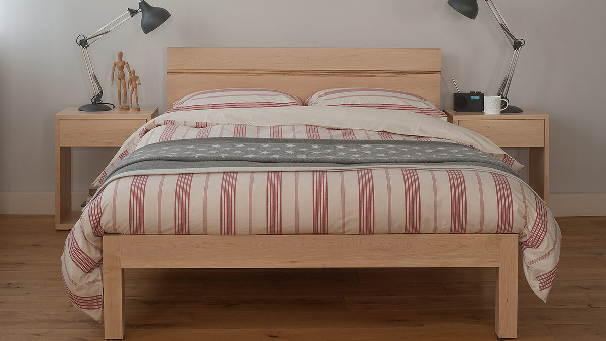 Modern solid wood Tibet bed with New England style bedding and Cube bedside tables.