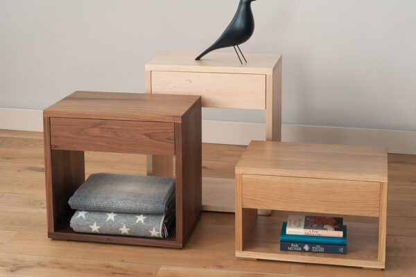 Cube bedside tables with storage drawer in 3 heights and made in a choice of wood.