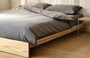 Rustic look low platform style Ki bed with grey bedding