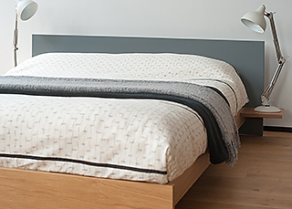 Koo is a contemporary low wooden bed with a headboard painted in your choice of colour