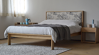 Summer bedroom with solid oak Shetland bed with floral headboard and oak bedside tables