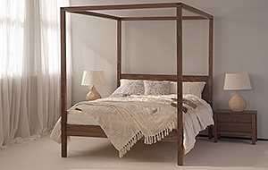 our hand crafted walnut orchid 4 poster bed is shown with draped bedding for a Boho look