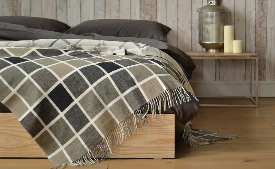 Low wooden platform bed The Ki given a cosy rustic look and shown with the Thin table