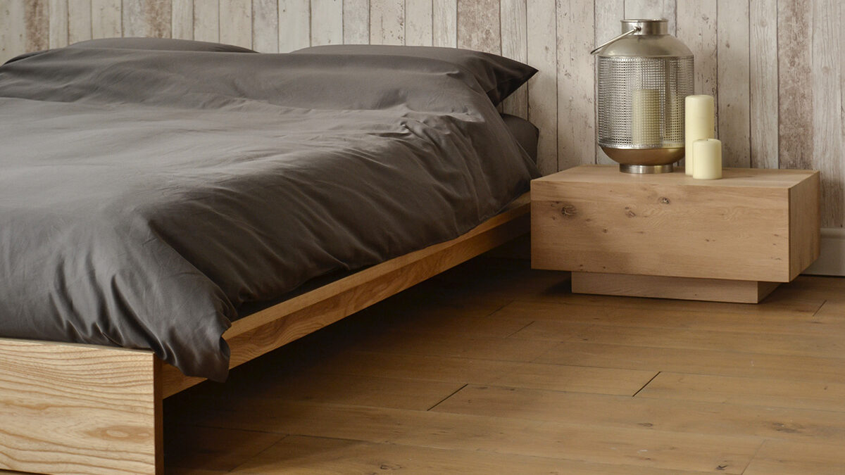 Angled view of our solid wood Ki Bed frame shown with Ethnicraft Madra table as bedside