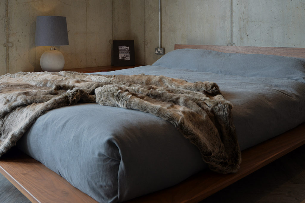 faux fur throw - silver wolf, linen bedding on walnut Oregon bed