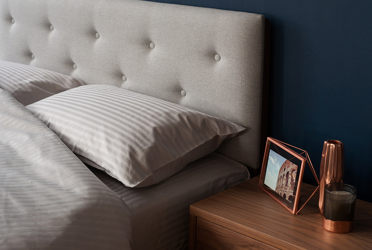 A closer view of the arran wooden bed padded headboard & satin stripe bedding