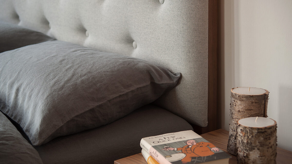 buttoned headboard bed with linen bedding close up