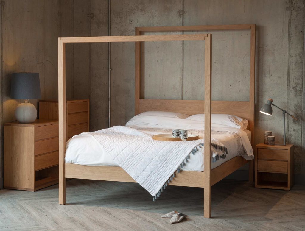 Oasis modern four poster bed hand made from solid wood shown with Oak Cube bedroom storage furniture.