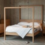 Oasis modern four poster bed hand made from solid wood shown with Oak Cube bedroom storage furniture.