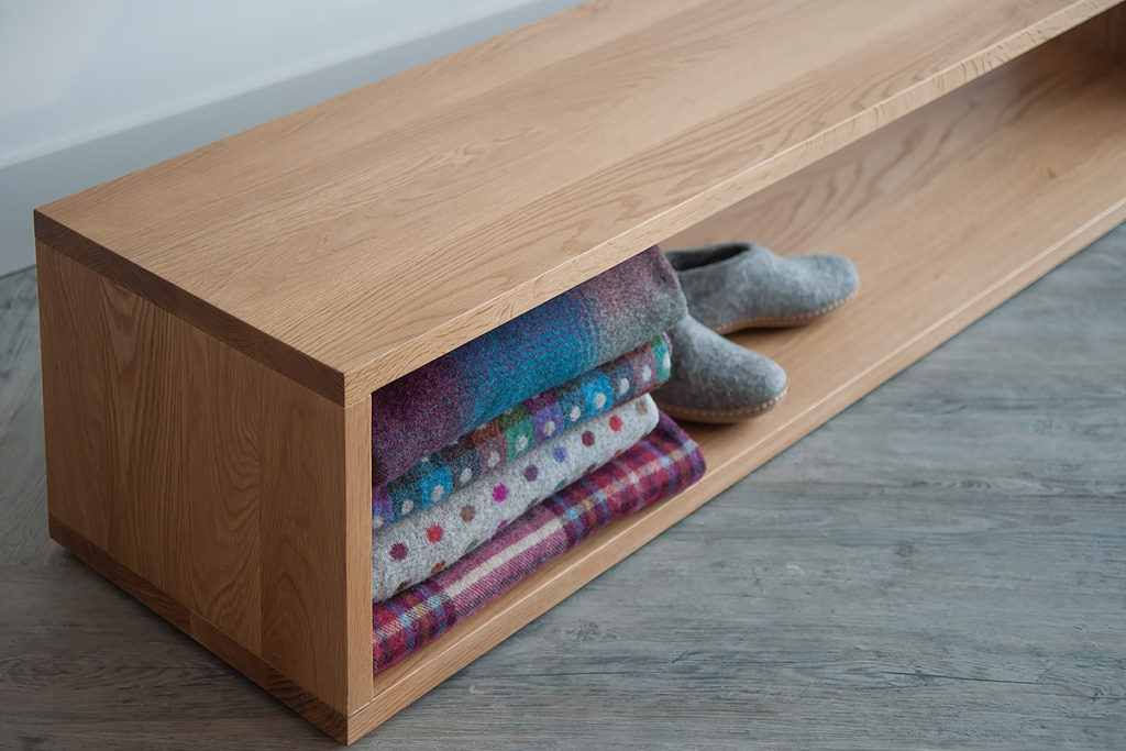 A close up view of the Black Lotus end-of-bed storage bench in Oak wood