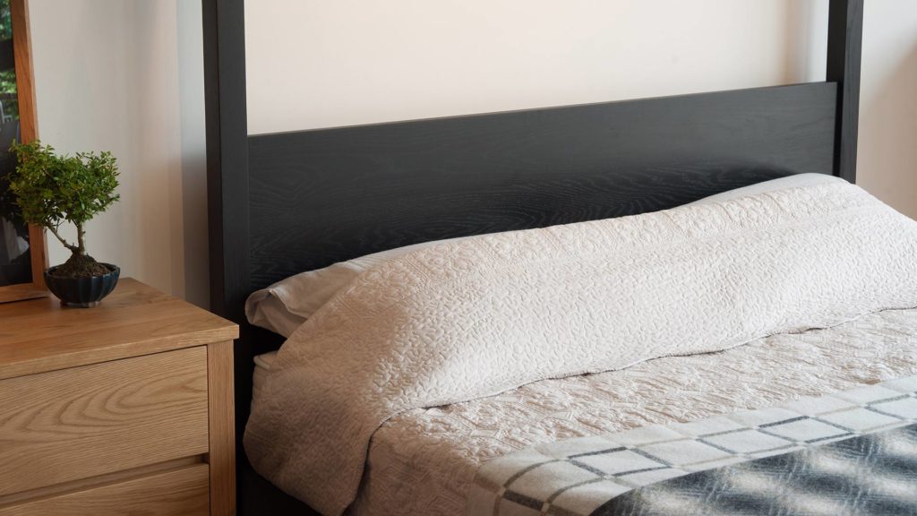 A closer view of the headboard of our black painted oak Orchid 4 Poster bed with black lotus 3 drawer chest in Oak