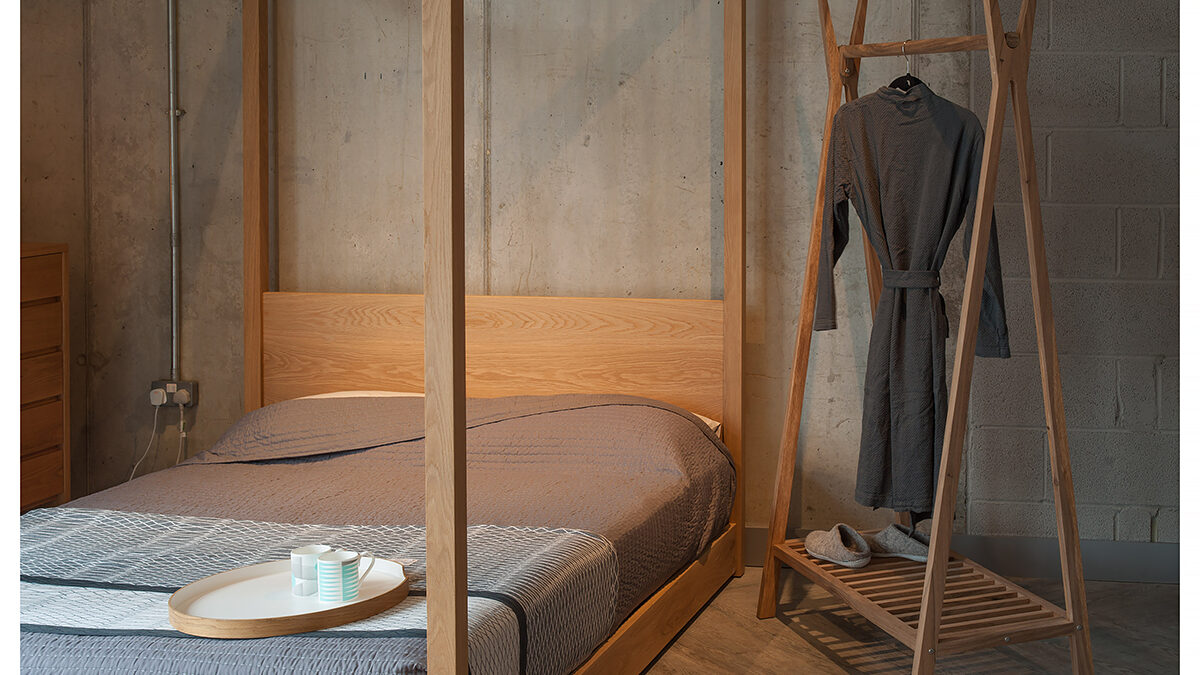 Wooden clothes hanging rail with our Contemporary Cube 4 Poster Bed in Oak