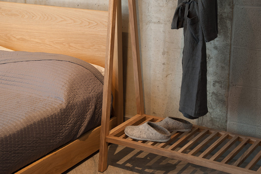 A view of the slatted shelf of the wooden clothes hanging rail