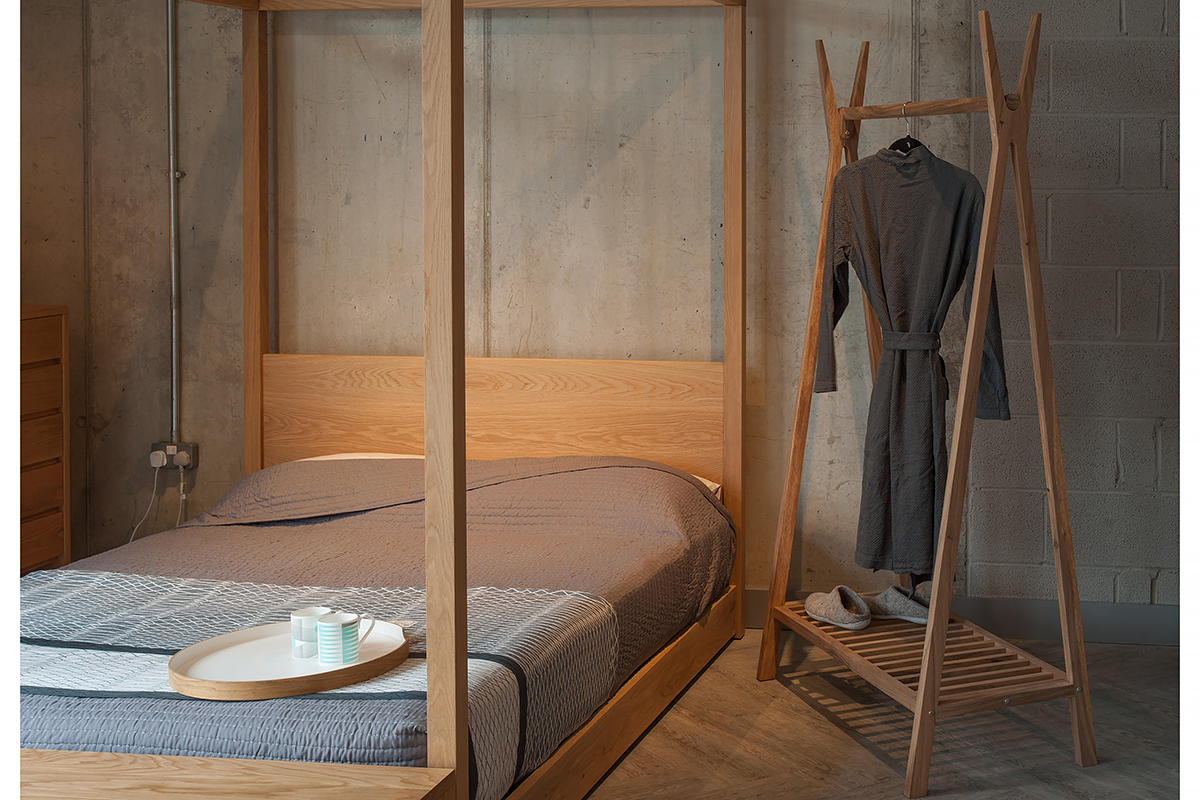 Wooden clothes hanging rail with our Contemporary Cube 4 Poster Bed in Oak