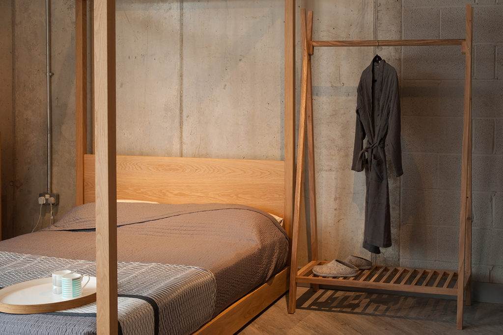 Wooden clothes rail with shelf next to our Cube 4 Poster Bed