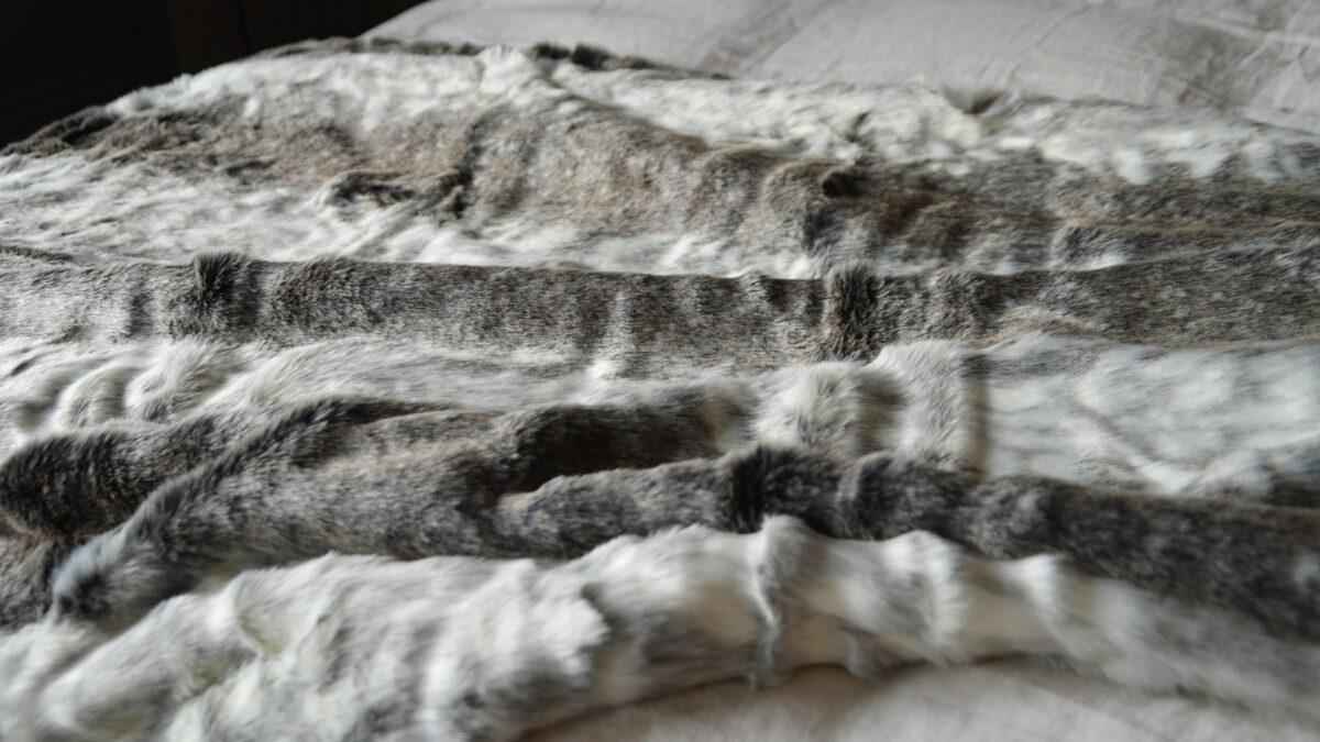 detail view of our softest faux fur arctic fox throw in grey colours and white