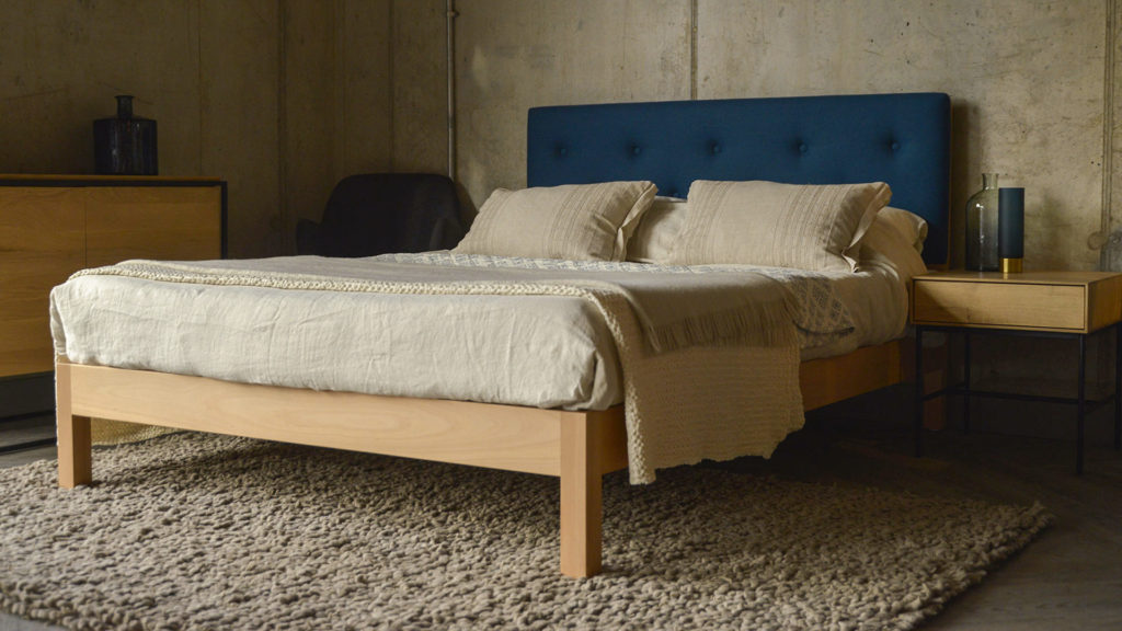 This Beech Arran bed has an upholstered headboard covered in Teal Blue wool felt