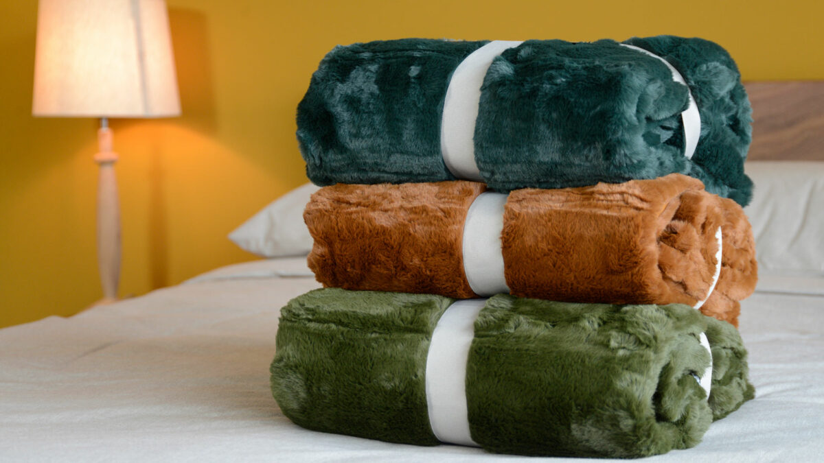 soft and luxurious faux fur throw in a choice of colours green, teal, and tan