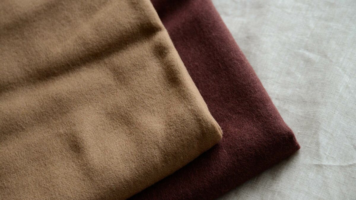 caramel coloured and wine coloured large wool throws shown folded together