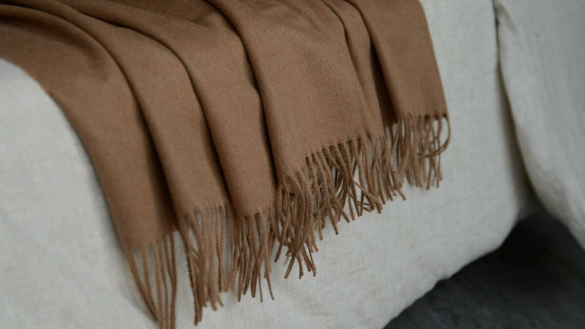 caramel coloured woollen large throw a close up of the fringed edges