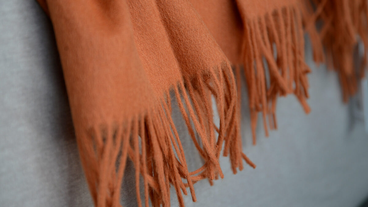 90% recycled Alpaca/wool mix throw in orange a close up view