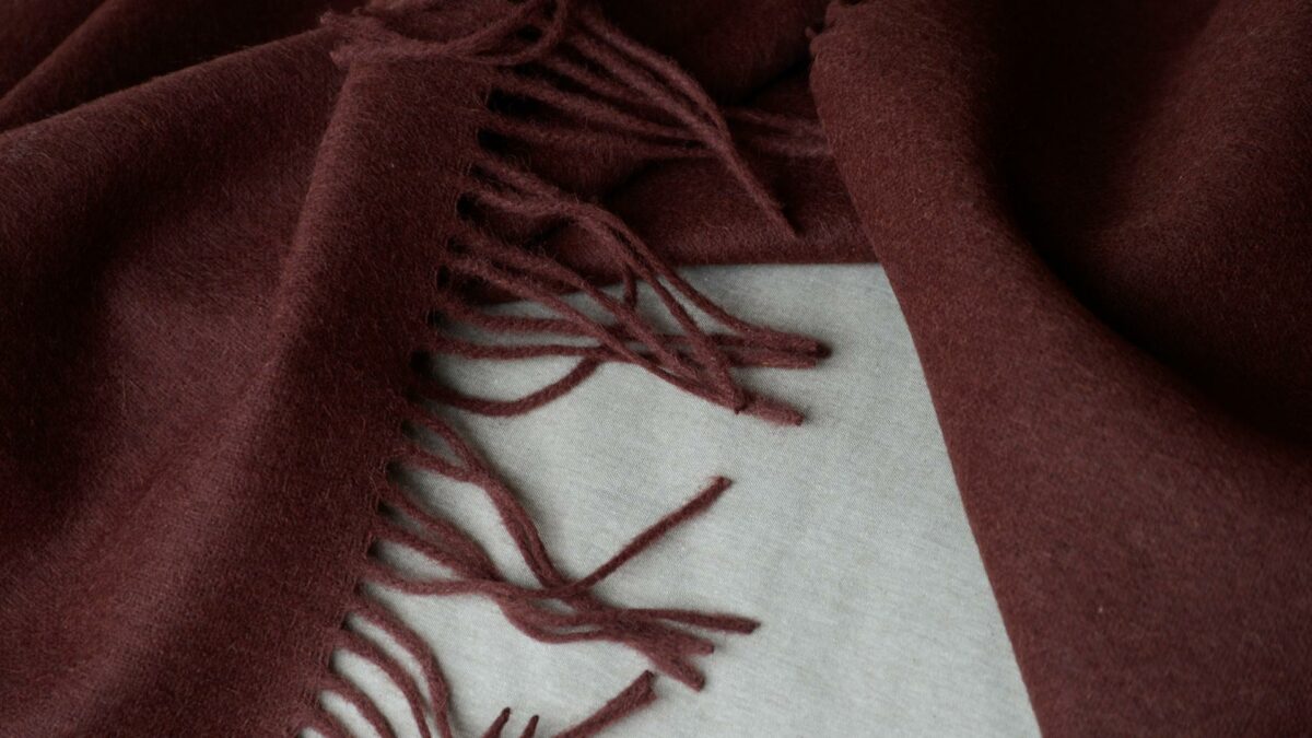 90% recycled Alpaca/wool mix throw in plum shown close up