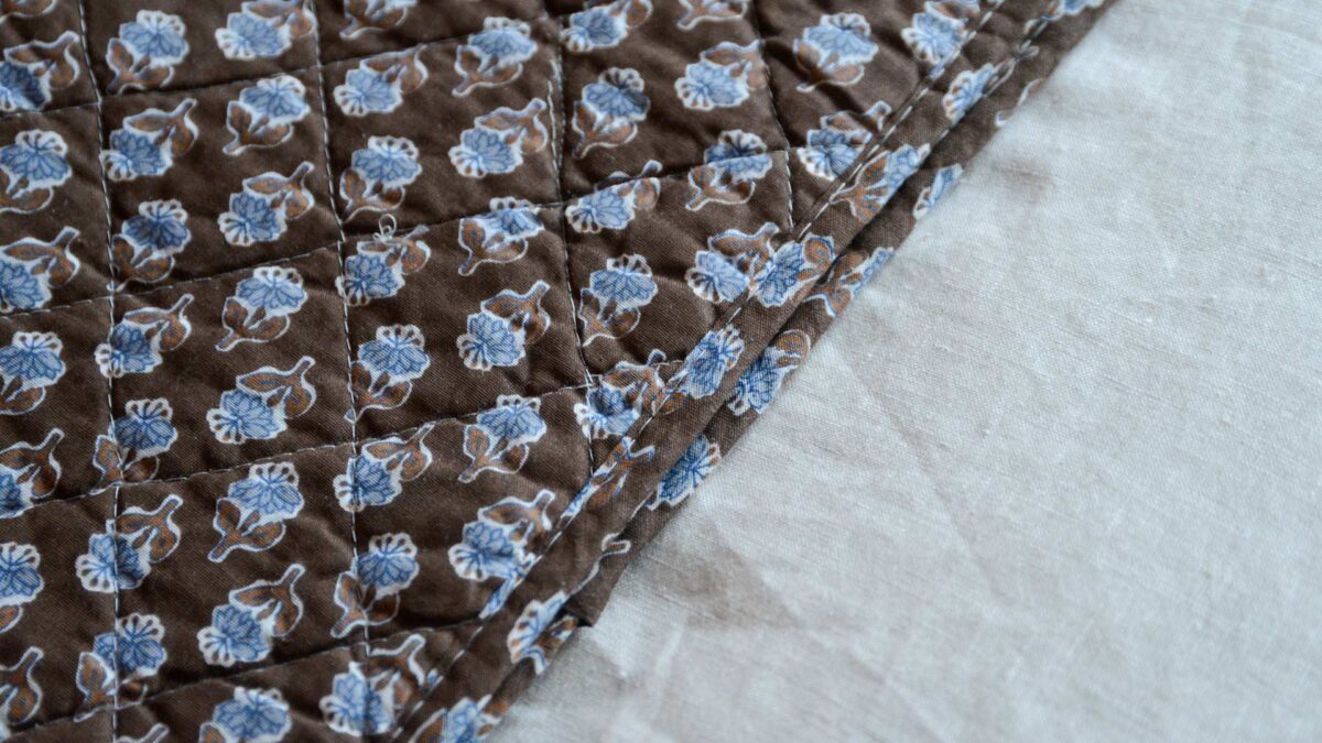 Brown Quilted Throw with Blue Flowers Stitch Detail
