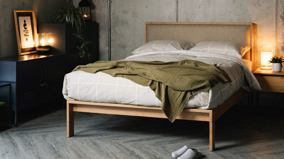 Scandinavian look bedroom featuring our Shetland bed in cherry wood, with headboard upholstered in Parquet Hessian