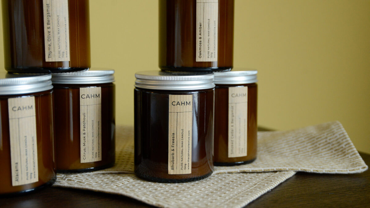 two stacks of three calm candles sat on walnut table top on a small cloth.