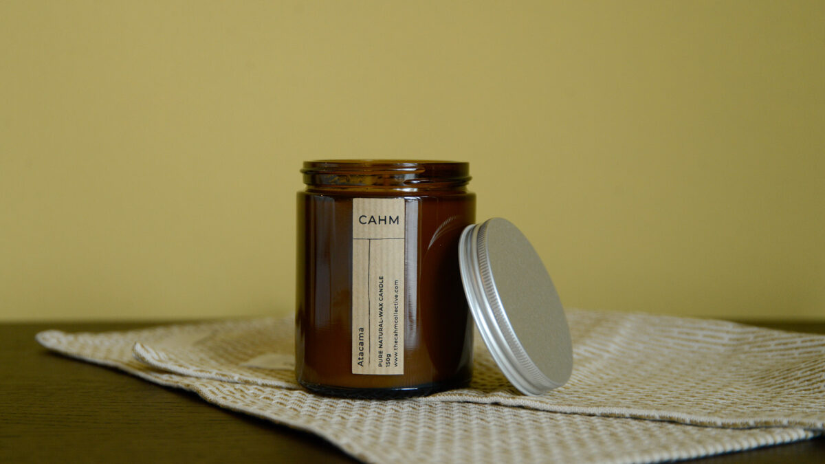 close up of open Atacama candle in glass jar with the lid balanced on the side.