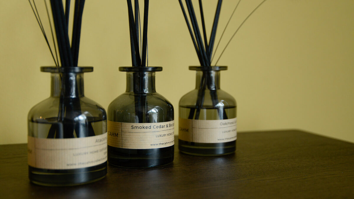 3 Cahm diffusers sat on walnut table top.