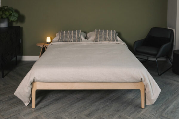 Maple wood Camden bed frame without a headboard and shown with taupe linen bedding