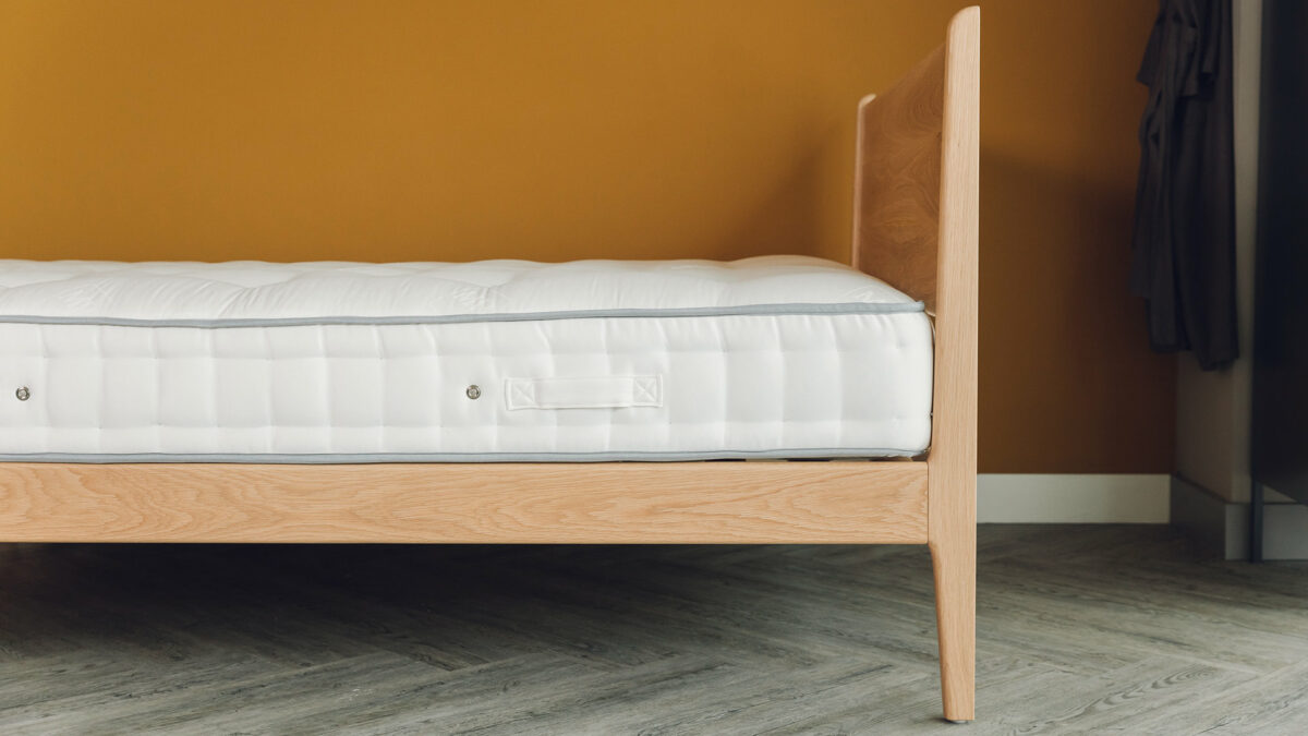 The Camden mid century style bed here made in solid oak wood and shown without bedding and from the side