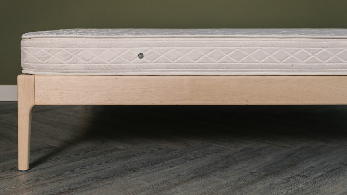 Maple wood Camden bed frame without a headboard and shown with a mattress