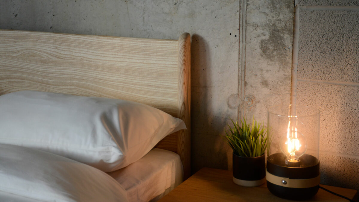 A close-up view of the headboard of the low wooden Carnaby bed in solid ash