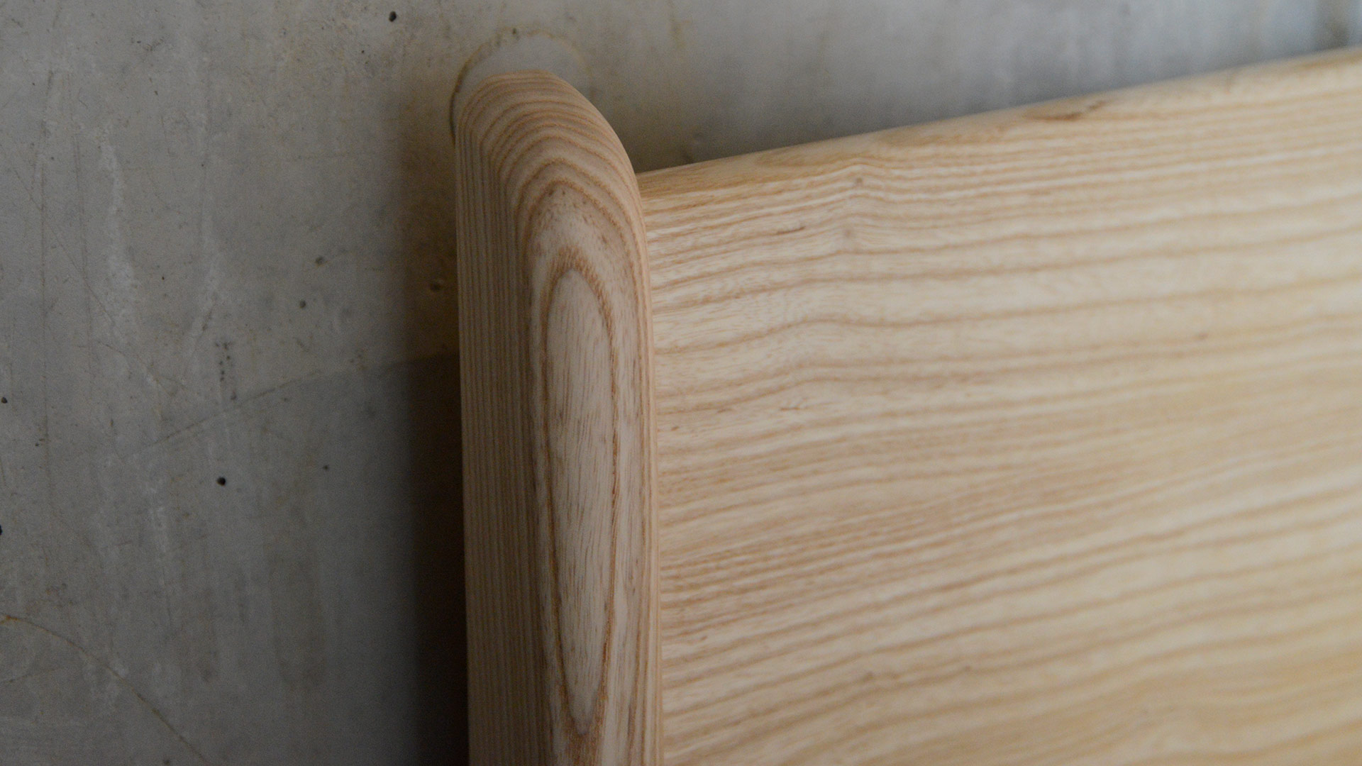 A close up of the hand crafted wooden Carnaby bed headboard - here in solid