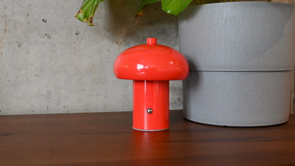 Image of a small retro style rechargeable light in a bright red colour.