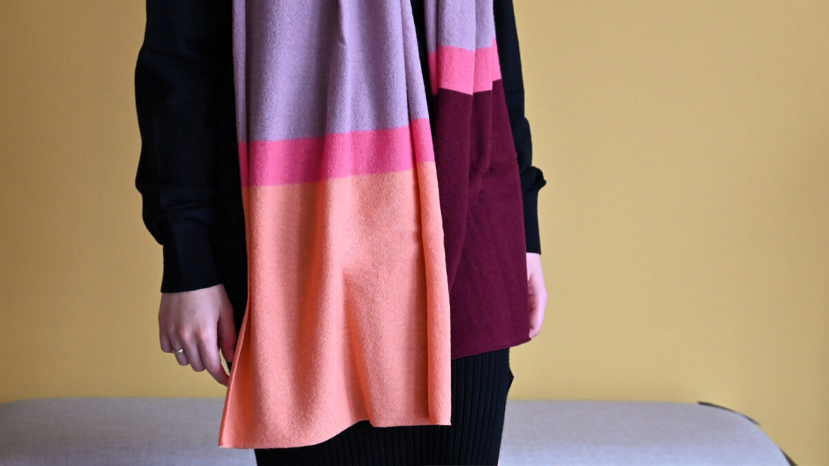 Colourful scarf in orange, pink, purple and maroon stripes.