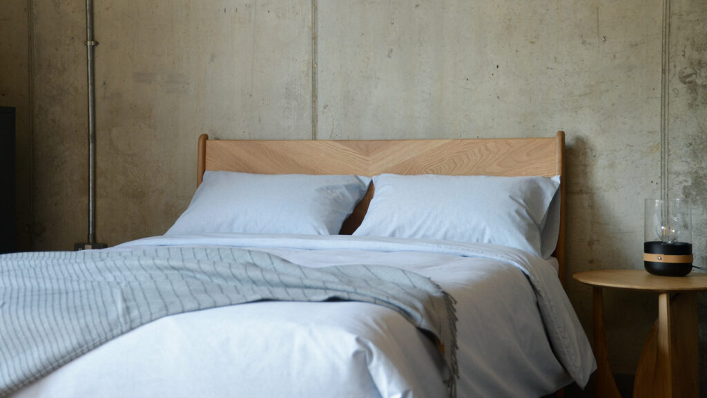 pale blue eco Bedding made from 100% recycled denim fibres shown on our wooden Hoxton bed