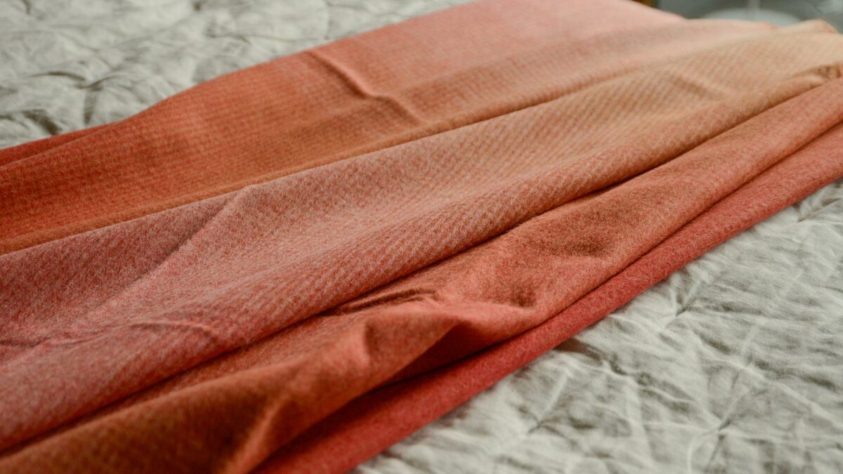 Elvang Orange Gradient Throw Over Bed